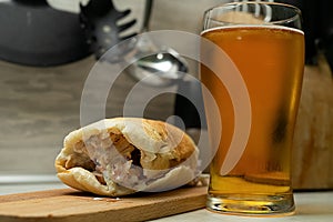 Falafel and fresh vegetables in pita bread on wooden table with beer.