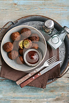 Falafel plate with spice and souce on metal tray