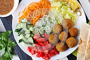 Falafel plate on top to garnish, carrot, cabbage, onion, cucumbers, tomatoes, still life, dish