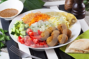 Falafel plate on top to garnish, carrot, cabbage, onion, cucumbers, tomatoes, still life, dish