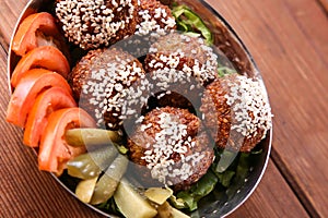 Falafel with sesame seeds and tomato served in dish isolated on background top view of hot mezza photo