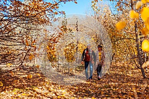 Fall activities. Senior couple walking in autumn park. Middle-aged man and woman hugging and chilling outdoors