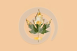 Fall and autumn flat lay with painted golden leaf on beige  background