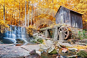 Fall or Autumn image of historic mill and waterfall photo