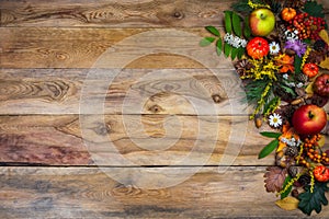 Fall background with pumpkin and green leaves on wooden table