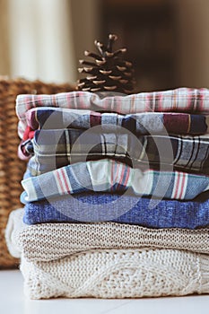 Fall casual woman fashion clothes set. Stack of plaid shirts and knitted sweaters