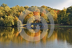 Fall color trees and stone bridge scenic landscape reflecting in a lake