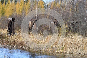 Fall colors and old bridge ruins are reflected in a river in Hayward, Wisconsin