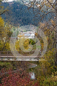 Fall colors wind over the Wenatchee River. A bridge and structures surrounded by vibrant red, yellow and orange foliage