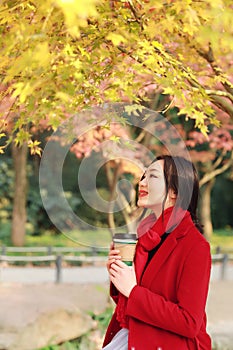 Fall concept - autumn woman drinking coffee