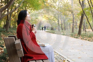 Fall concept - autumn woman drinking coffee