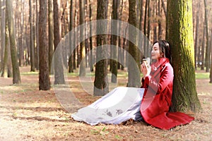 Fall concept - autumn woman drinking coffee