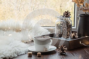 Fall cozy still life on windowsill at home interior. Cup of coffee at home warm fluffy furskin. Hygge.