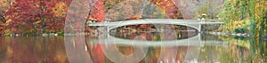 Fall dawn panorama of Bow Bridge in Central Park.