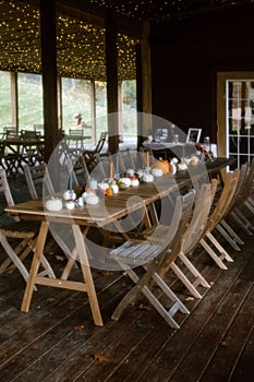 Fall dinner party decor featuring pumpkin-adorned tables in an enchanting outdoor space