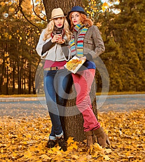 Fall Fashion. Friends Woman walk in Autumn park