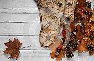 Fall flat lay composition, with warm cozy knitted blanket, autumn leaves and copy space.