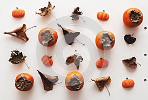 Fall flatlay with persimmons, pumpkin candies and dry leaves