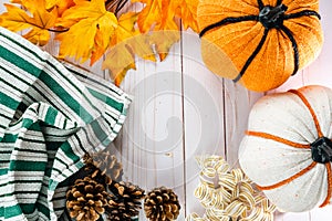 Fall flatlay, top down view of pumpkins, gold ribbon, pine cones, and maple leaves, with copyspace for autumn projects