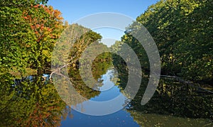 Fall foliage reflected on river in Unity Maine