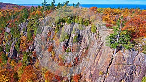 Fall forest in the mountains with aspens and pine trees and cliff walls