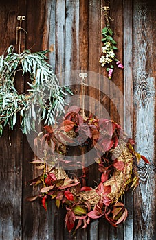 Fall front porch. autumn wreath and pumpkins on old wooden rustic background at doors.