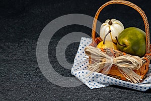 Fall fruit basket with yellow and green pears, white pumpkin