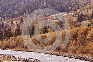 Fall golden countryside view, mountain river, village - autumn atmosphere background.