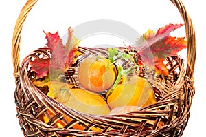 Fall harvest: pumpkin and autumn leaves in the basket isolated o