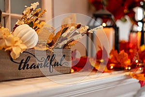 Fall holiday mantel decorated with colorful leaves and twinkle lights