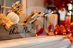 Fall holiday mantel decorated with colorful leaves and twinkle lights photo