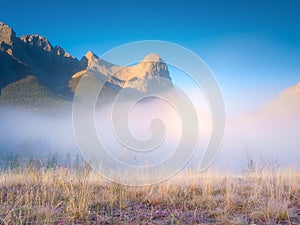 Fall landscape. Foggy landscape in the morning. Mountain peak. Sunbeams in a valley. Field in a mountain valley at dawn.