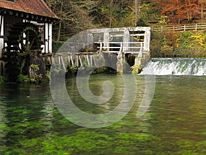 Fall landscape at lake Blautopf with old water mill