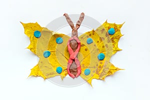 Fall Leaf Crafts for Kids. Craft handmade butterfly from dry yellow leaves and red, brown and blue plasticine, modeling clay. Ide