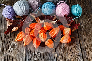 Fall leaves and wool clew on rustic wooden background