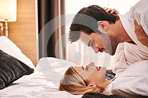 Fall in love. Young couple lying together in hotel room bed