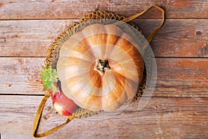 Fall pumpkin in a mesh cotton eco bag with apples, cardoncelli mushrooms, walnuts, leaves on old wooden boards. Autumn shopping,