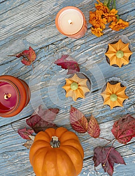 Fall pumpkin spice cupcakes with creamy frosting and autumn toppings candles and autumn leaves .