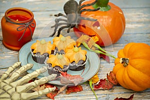 Fall pumpkin spice cupcakes with creamy frosting and autumn toppings. Halloween decorations and cupcakes.