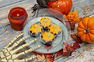 Fall pumpkin spice cupcakes with creamy frosting and autumn toppings. Halloween decorations and cupcakes.