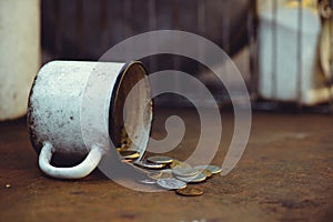 The fall of the Russian ruble, poverty and poverty scattered coins in the old mug on a rusty background, sanctions