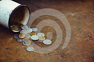 The fall of the Russian ruble, poverty and poverty scattered coins in the old mug on a rusty background, sanctions