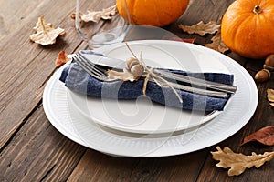 Fall season table setting with leaves and pumpkins