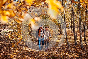 Fall season walk. Senior family couple walking in autumn park. Man and woman relaxing outdoors