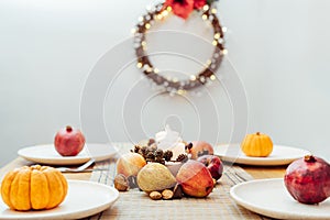 Fall table setting for celebration Thanksgiving day family party. Autumn composition with candles, fruits, nuts and