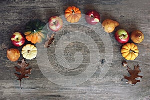 Fall Thanksgiving Harvest Background with Apples, Pumpkins, Pears, Leaves, Acorn Squash and Nut Border Over Wood, Shot Directly Ab