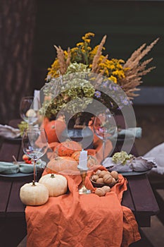 Fall themed holiday table setting arrangement for a seasonal party, selective focus