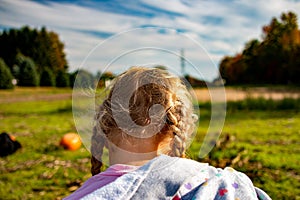 Fall themed photo of a little girl in a pumpkin patch