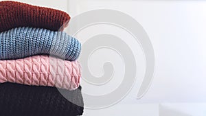 Fall winter fashion trends. Stack of cozy knitted sweaters in retail shop, store. Fashion shopping sale background with copy space