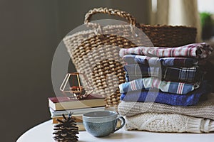 Fall woman fashion casual clothes set. Stack of plaid shirts, cup of tea and pine cone